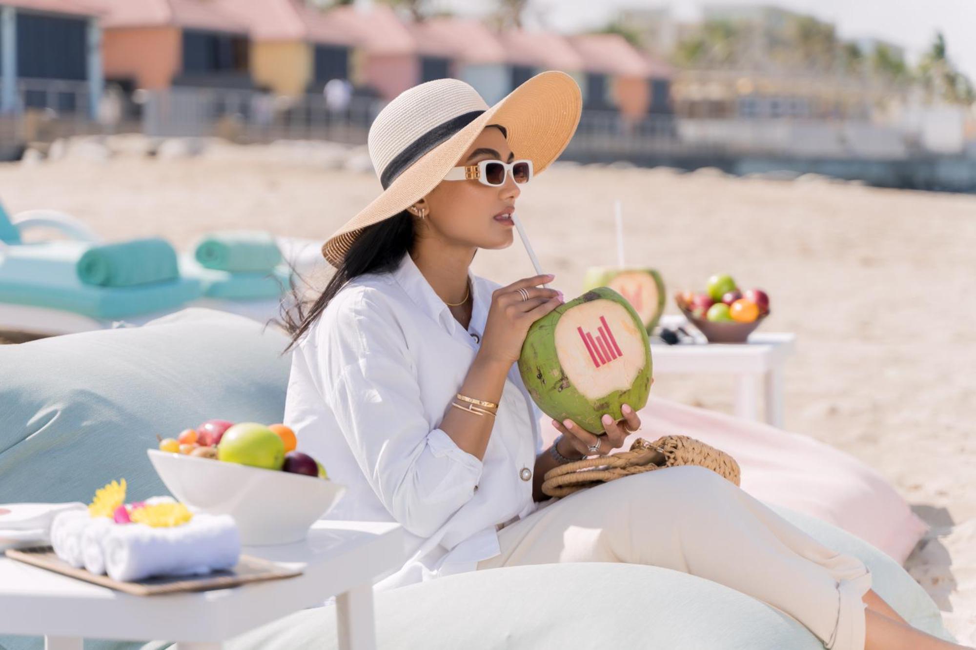 Grand Millennium Muscat Hotel Exterior foto A woman drinking from a coconut